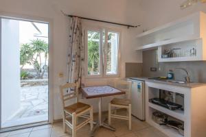 a kitchen with a table and chairs and a window at Evagelia's Place in Agios Ioannis Mykonos