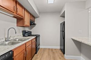a kitchen with a sink and a black refrigerator at Newly Renovated Unit in Central Spfld #101 in Springfield