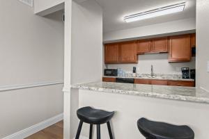 a kitchen with two black stools at a counter at Newly Renovated Unit in Central Spfld #101 in Springfield