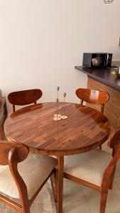 a wooden table with four chairs around it at ValdOrea Residences in Entebbe +32 photos
