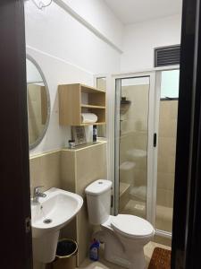 a bathroom with a toilet and a sink and a shower at ValdOrea Residences in Entebbe