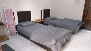 a room with two beds and a table with a table at AZ Guest House & Inn in Pasir Mas
