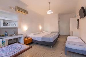 a hotel room with two beds and a sink at Evagelia's Place in Agios Ioannis Mykonos