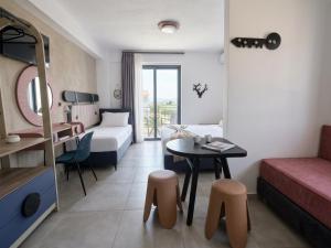 a hotel room with a bed and a table and chairs at Olea Luxury Suites in Asprovalta