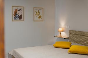 a bedroom with a bed with yellow pillows and a lamp at Arches in Agria