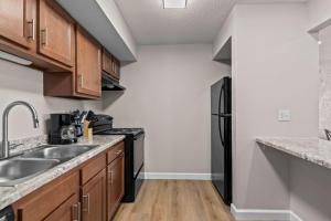 a kitchen with a sink and a black refrigerator at Newly Renovated Unit in Central Spfld #103 in Springfield
