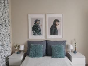 a bedroom with two pictures above a bed with blue pillows at CASA MINI 5 in Pécs