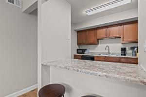 a kitchen with wooden cabinets and a granite counter top at Newly Renovated Unit in Central Spfld #103 in Springfield