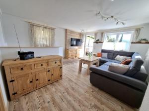 a living room with a blue couch and a tv at Ferienhaus zum Eiskeller in Stadt Wehlen +4 photos
