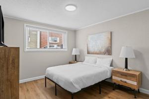 a bedroom with a white bed and a window at Newly Renovated Unit in Central Spfld #103 in Springfield +9 photos