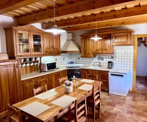a kitchen with wooden cabinets and a wooden table at The Szigliget Residence in Szigliget