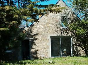 a stone house with a window in a yard at Gîte entre l'océan et le golfe in Surzur