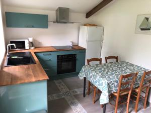 a small kitchen with a table and a refrigerator at Gîte entre l'océan et le golfe in Surzur
