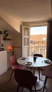 a white table and chairs in a room with a window at Asterisco Casa Vacanze in Turin +2 photos