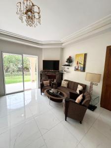 a large living room with couches and a chandelier at Cozy Seaside Villa in Bir Jedíd Saint-Hubert