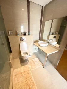 a bathroom with two sinks and a toilet and a mirror at Cozy Seaside Villa in Bir Jedíd Saint-Hubert +19 photos