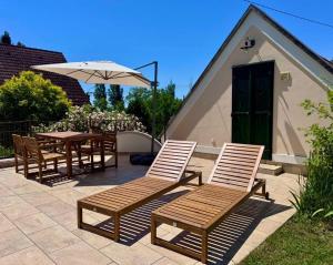 a patio with a table and chairs and an umbrella at The Szigliget Residence in Szigliget