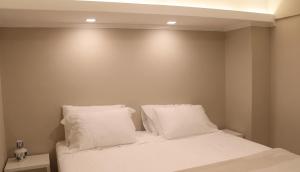 a bedroom with a bed with white sheets and pillows at Casa da Ópera in Diamantina