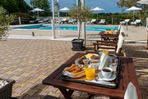 a tray of food on a table next to a pool at Aspasia Studios in Lixouri