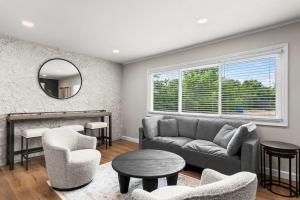 a living room with a couch and chairs and a mirror at Newly Renovated Unit in Central Spfld #203 in Springfield
