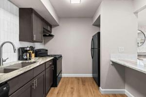 a kitchen with a black refrigerator and wooden floors at Newly Renovated Unit in Central Spfld #203 in Springfield
