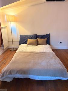 a large bed in a room with a lamp at Asterisco Casa Vacanze in Turin