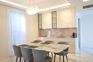 a kitchen with a dining room table and chairs at Palmera Dream Vila in Sarandë