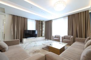 a living room with a couch and a tv at Palmera Dream Vila in Sarandë