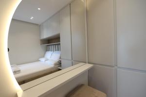 a small room with a bed and a mirror at Palmera Dream Vila in Sarandë +38 photos
