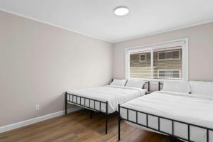 two beds in a room with a window at Newly Renovated Unit in Central Spfld #204 in Springfield