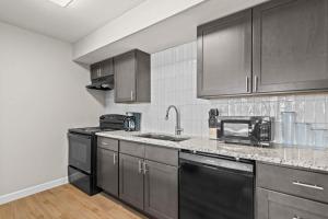 a kitchen with black cabinets and a sink at Newly Renovated Unit in Central Spfld #204 in Springfield