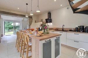 a kitchen with a long island with a breakfast bar at Du rocher in Plélo +32 photos
