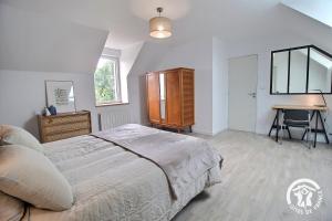a bedroom with a bed and a desk and a table at Du rocher in Plélo