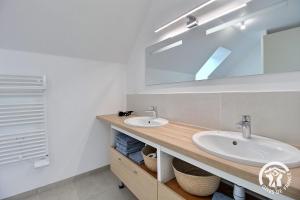 a bathroom with two sinks and a mirror at Du rocher in Plélo