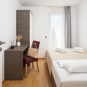 a bedroom with two beds and a desk and a chair at Sunny resort apartment with pool access in Zadar +37 photos
