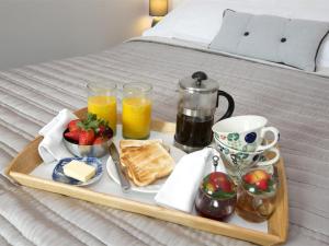 a tray with breakfast foods and drinks on a bed at 1 Bed in Ripon oc-g0023 in Winksley
