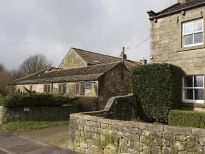 a house with a stone wall in front of it at 1 Bed in Ripon oc-g0023 in Winksley