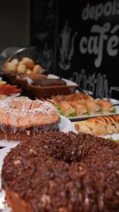 a table full of different types of food on plates at Hotel Boa Viagem in Barra do Garças +25 photos