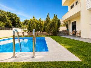 a swimming pool in a yard next to a house at Villa Rose Ground Floor - Private Swimming Pool Garden in Koskinou +22 photos