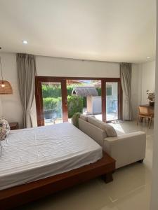 a bedroom with a large bed and a couch at Arunta Samui in Lipa Noi