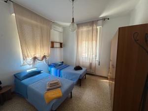 two beds in a small room with blue beds at Affittacamere VITRUVIO in Fano
