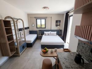 a hotel room with two beds and a table at Olea Luxury Suites in Asprovalta