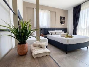a bedroom with two beds and a potted plant at Olea Luxury Suites in Asprovalta