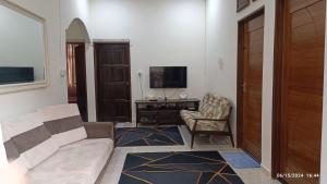 a living room with a couch and a chair and a television at AZ Guest House & Inn in Pasir Mas