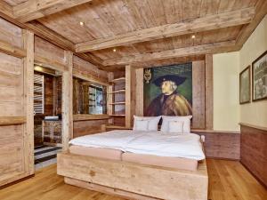 a bedroom with a large bed with a painting of a man at Emmat Apartments in Leutasch