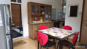a kitchen with a table and red chairs at AZ Guest House & Inn in Pasir Mas