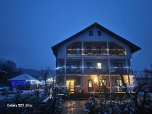 a large white house with christmas lights on it at Casa Joe in Râmnicu Vâlcea