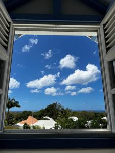 a window view of a blue sky with clouds at VILLA CARAIBE in Sainte-Luce