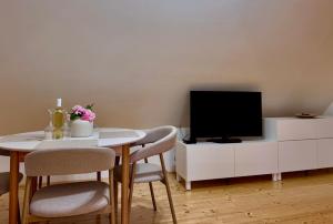 a living room with a table and a tv at The Szigliget Residence in Szigliget