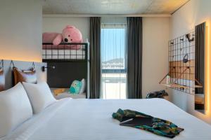 a hotel room with a bed with a towel on it at Moxy Outletcity Metzingen in Metzingen +63 photos